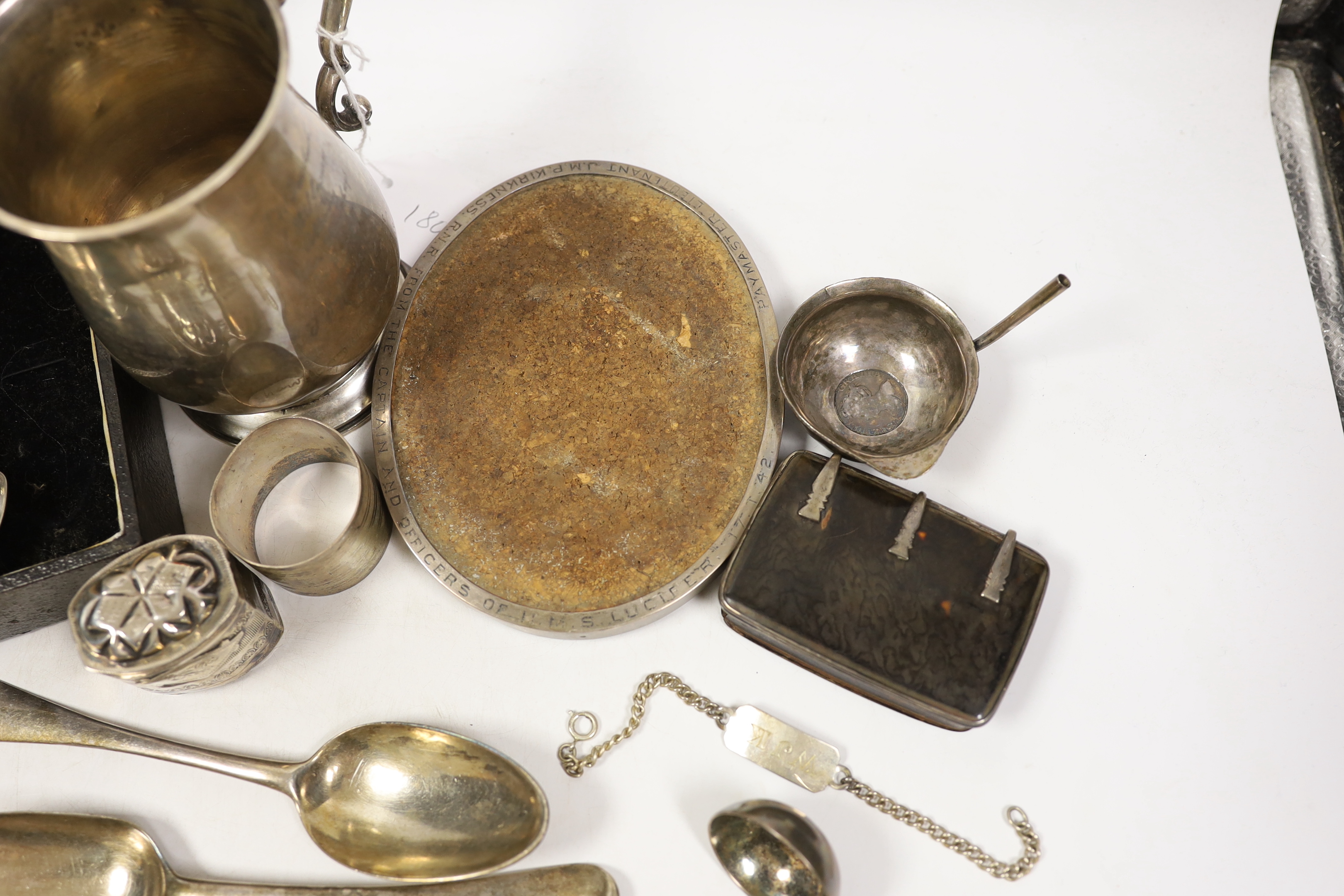 Assorted silver items including a silver mug engraved with signatures and inscription relating to Lieut. Commander S.J.M.P. Kirkness, R.N.R., London, 1942, 13cm, four 18th century base mark table spoons, a George IV cadd